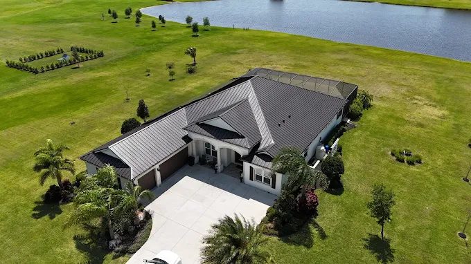 Aerial view of a completed metal roof on a lakefront home