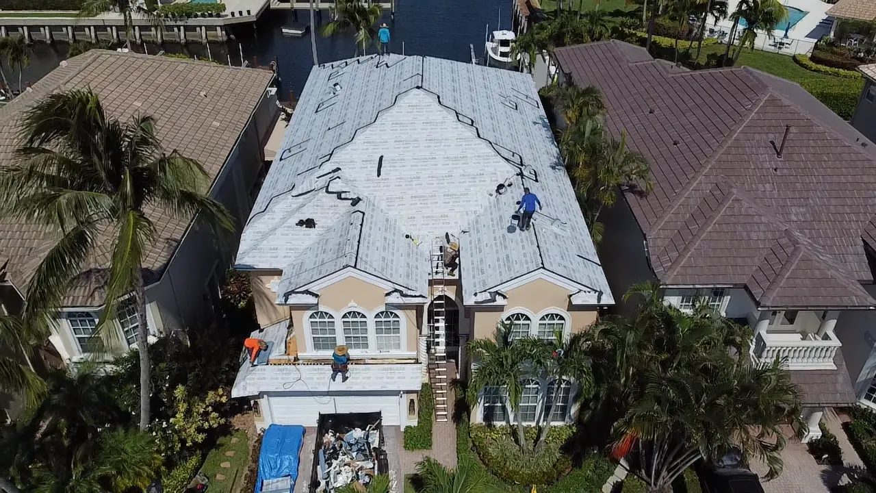 Hunter Construction crew replacing a roof on a waterfront home in South Florida